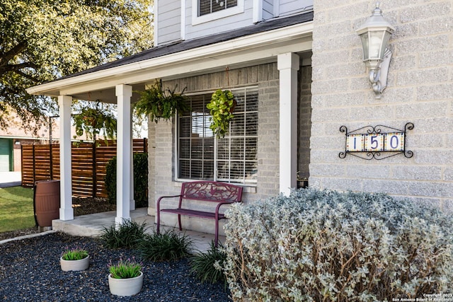 property entrance with a porch and fence