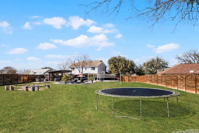 view of yard featuring a trampoline, a fenced backyard, and a pergola