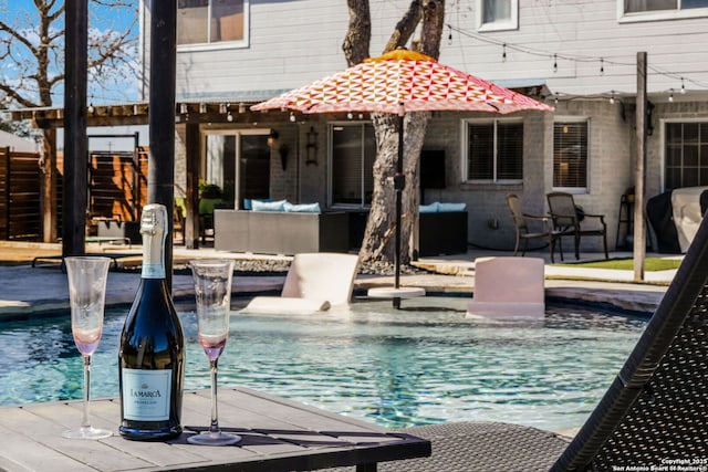 outdoor pool featuring a patio area, fence, and an outdoor hangout area