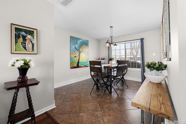 dining room with an inviting chandelier, visible vents, and baseboards