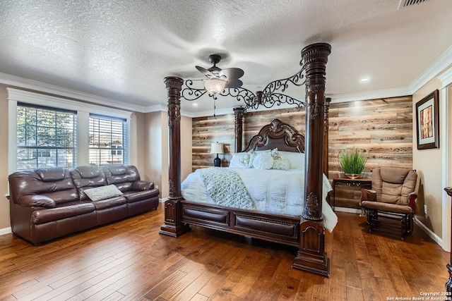 bedroom with wood-type flooring, crown molding, and a textured ceiling