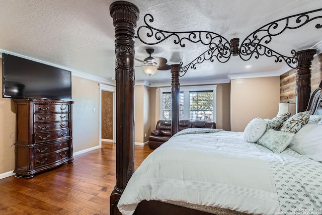 bedroom with crown molding, a textured ceiling, baseboards, and hardwood / wood-style flooring