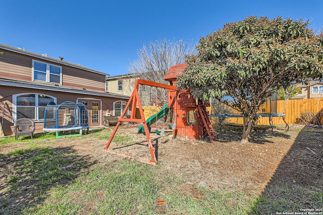 view of play area featuring a trampoline and fence