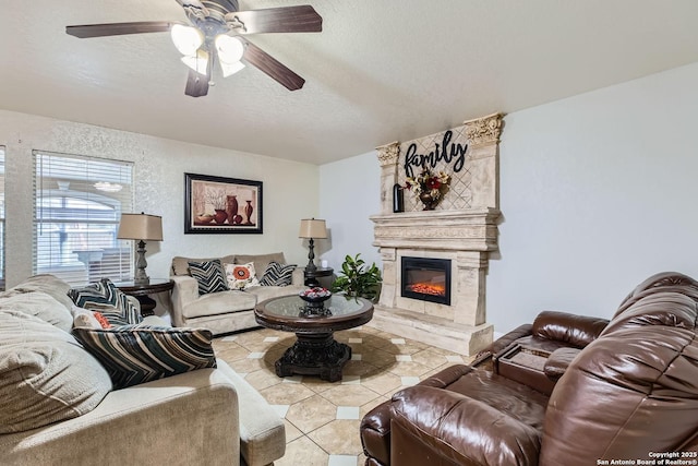 tiled living room featuring a fireplace, a textured ceiling, and ceiling fan