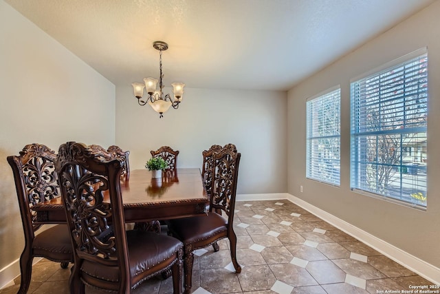 dining space featuring light tile patterned floors, baseboards, and an inviting chandelier