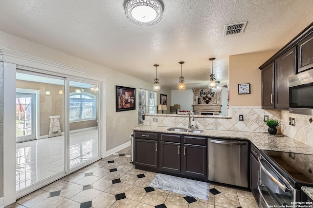 kitchen with tasteful backsplash, visible vents, a peninsula, stainless steel appliances, and a sink