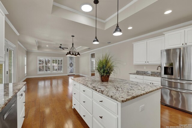 948 Hudson, New Braunfels, TX 78130 - kitchen featuring stainless steel appliances, light wood-style floors, open floor plan, a center island, and a raised ceiling