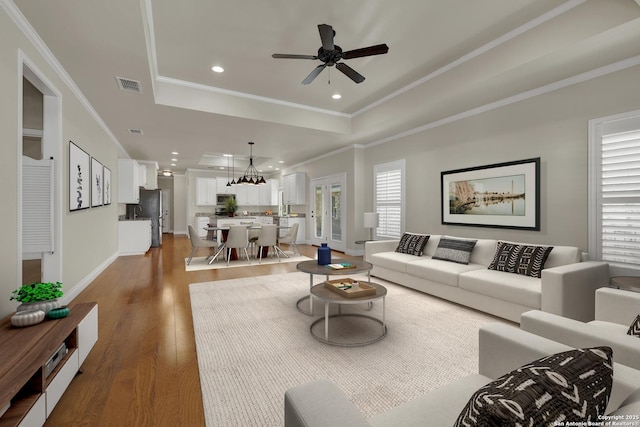 948 Hudson, New Braunfels, TX 78130 - living room featuring crown molding, visible vents, a raised ceiling, and wood finished floors