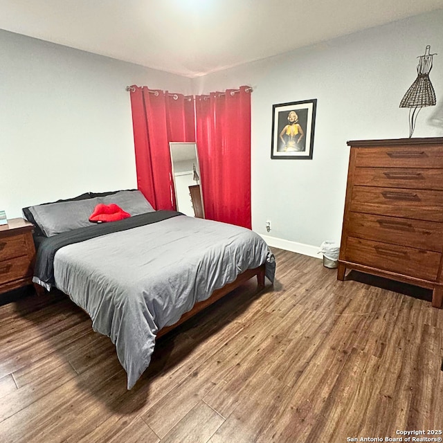 bedroom with wood finished floors and baseboards