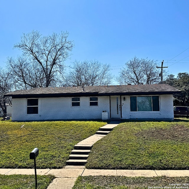 single story home with brick siding and a front lawn