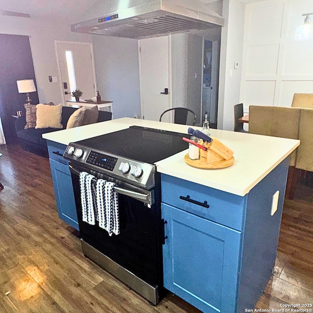 kitchen with blue cabinets, ventilation hood, dark wood-type flooring, and stainless steel electric range