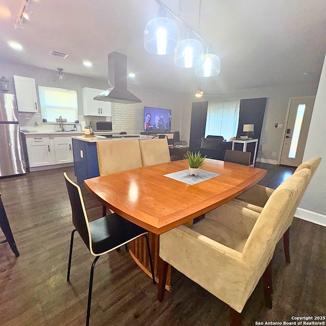 dining area featuring a healthy amount of sunlight, visible vents, dark wood finished floors, and baseboards