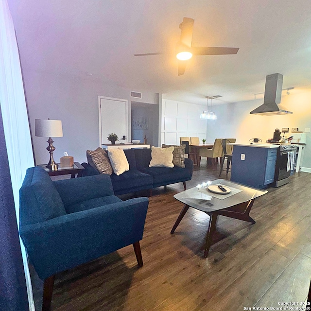 living area with dark wood-type flooring, visible vents, and a ceiling fan