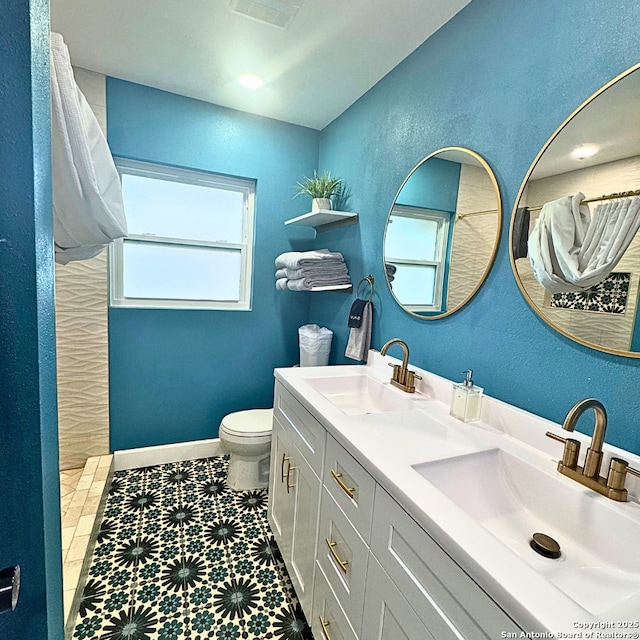 bathroom with toilet, baseboards, a sink, and a shower with shower curtain