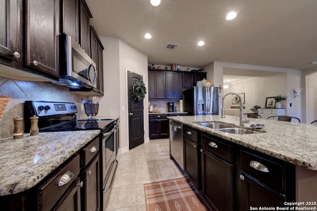 kitchen with a kitchen island with sink, recessed lighting, stainless steel appliances, a sink, and visible vents