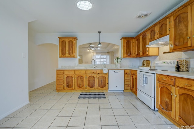 kitchen featuring white appliances, visible vents, light countertops, under cabinet range hood, and a sink