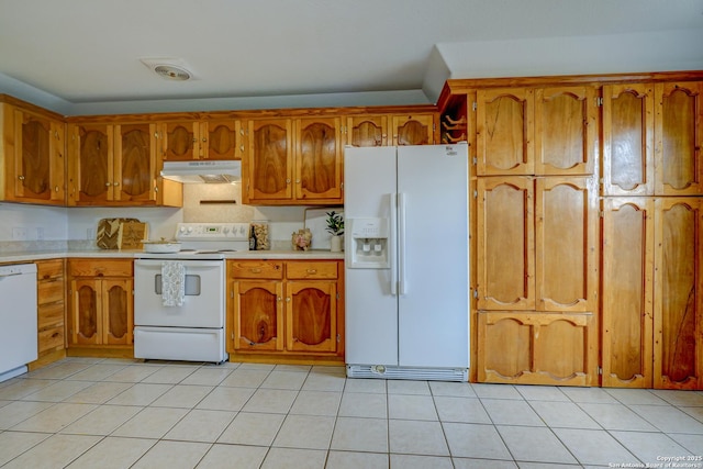 kitchen with brown cabinetry, white appliances, light countertops, and under cabinet range hood