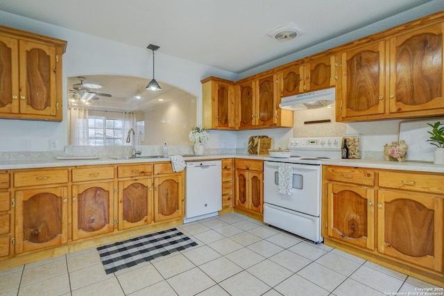 kitchen with white appliances, under cabinet range hood, and brown cabinetry