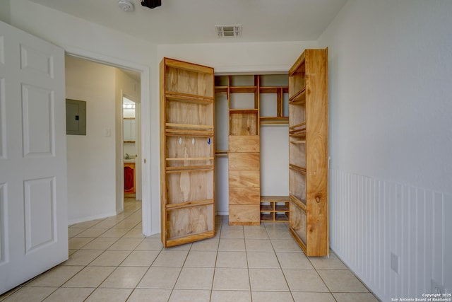 interior space featuring visible vents, light tile patterned floors, a closet, and electric panel