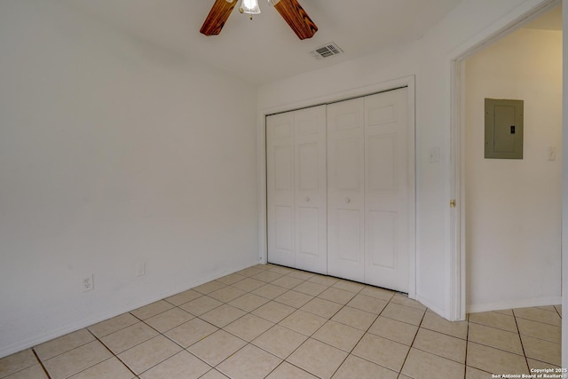 unfurnished bedroom featuring ceiling fan, light tile patterned floors, visible vents, a closet, and electric panel