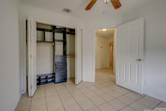 unfurnished bedroom with light tile patterned floors, ceiling fan, a closet, and visible vents