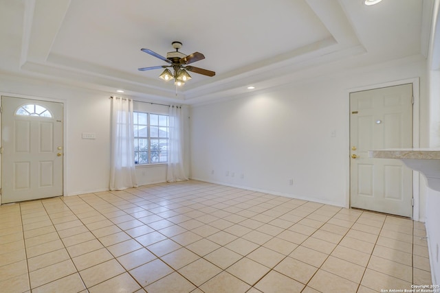 foyer featuring baseboards, a raised ceiling, a ceiling fan, and light tile patterned flooring