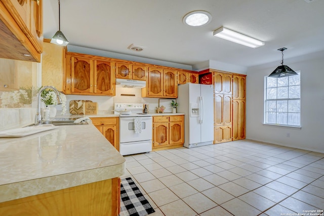 kitchen with light tile patterned floors, under cabinet range hood, white appliances, a sink, and light countertops