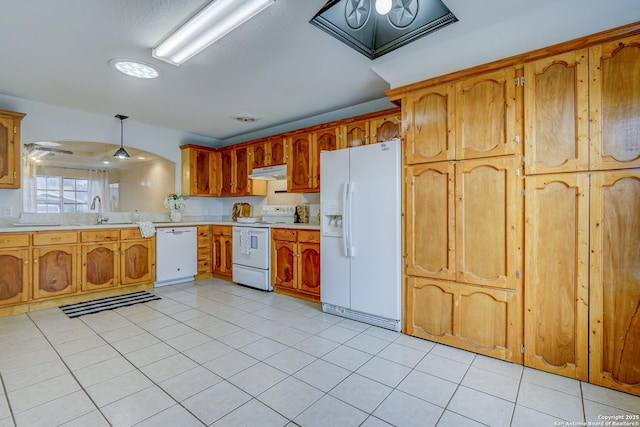 kitchen with white appliances, under cabinet range hood, light countertops, and brown cabinetry