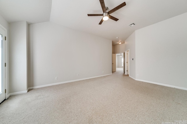 empty room featuring light colored carpet, visible vents, lofted ceiling, and baseboards