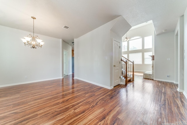 unfurnished room featuring visible vents, stairway, baseboards, and wood finished floors