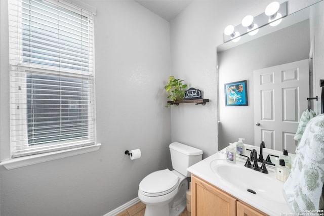 bathroom featuring vanity, toilet, and baseboards