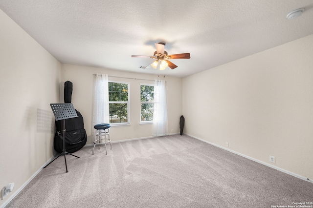 unfurnished room featuring a ceiling fan, a textured ceiling, baseboards, and carpet flooring