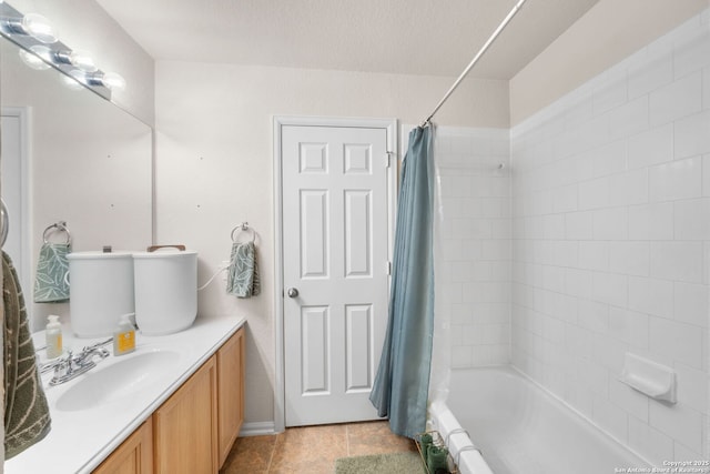 full bath with tile patterned flooring, shower / tub combo with curtain, vanity, and a textured ceiling