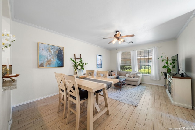 dining area featuring visible vents, crown molding, light wood-style flooring, and baseboards