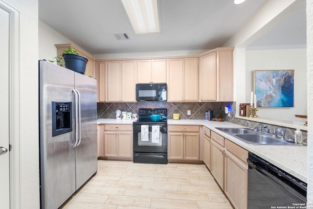 kitchen featuring light brown cabinets, a sink, visible vents, black appliances, and tasteful backsplash