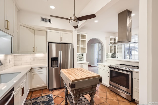 kitchen with stainless steel appliances, a sink, visible vents, open shelves, and island exhaust hood