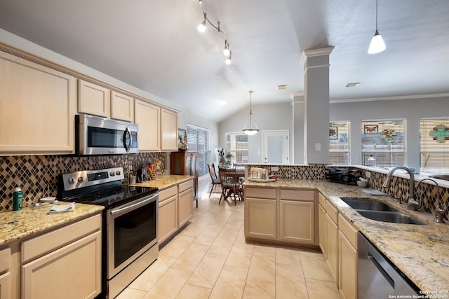 kitchen with decorative columns, appliances with stainless steel finishes, vaulted ceiling, light brown cabinets, and a sink