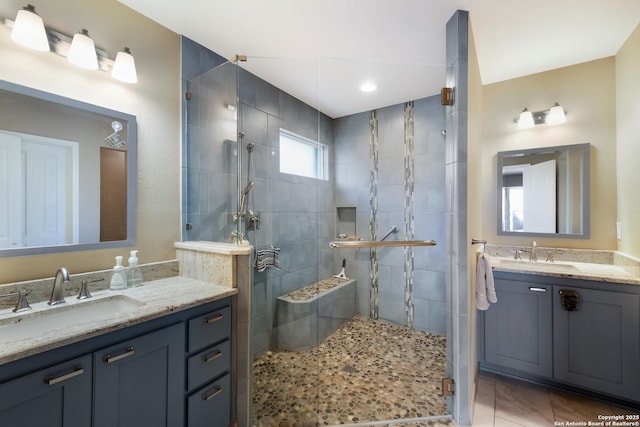 full bathroom with a stall shower, two vanities, a sink, and tile patterned floors