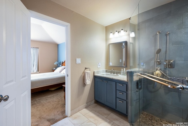 ensuite bathroom with a tile shower, vanity, ensuite bath, baseboards, and tile patterned floors