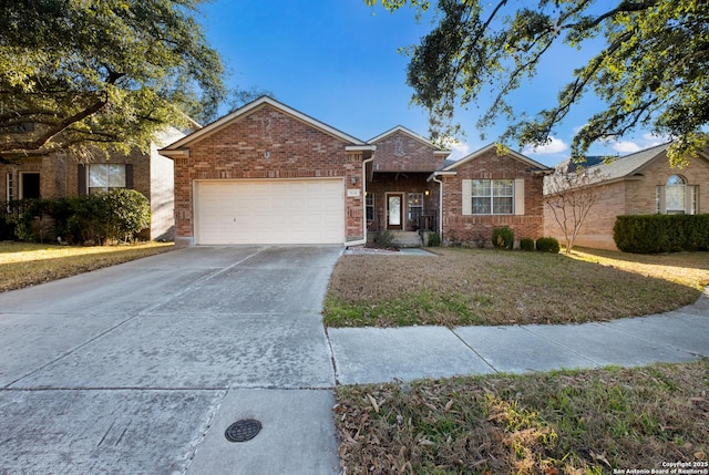 ranch-style home featuring an attached garage, a front lawn, concrete driveway, and brick siding