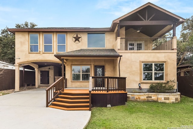 view of front of property with ceiling fan, driveway, a balcony, and stucco siding