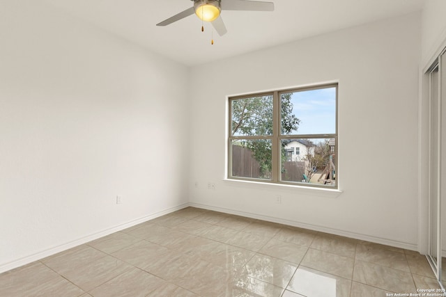 unfurnished room with a ceiling fan and baseboards