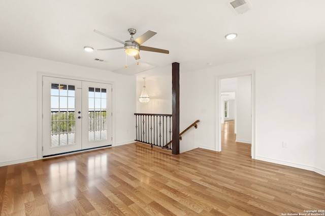 empty room with light wood-type flooring, french doors, and visible vents