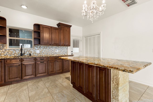 kitchen with tasteful backsplash, visible vents, a sink, and open shelves