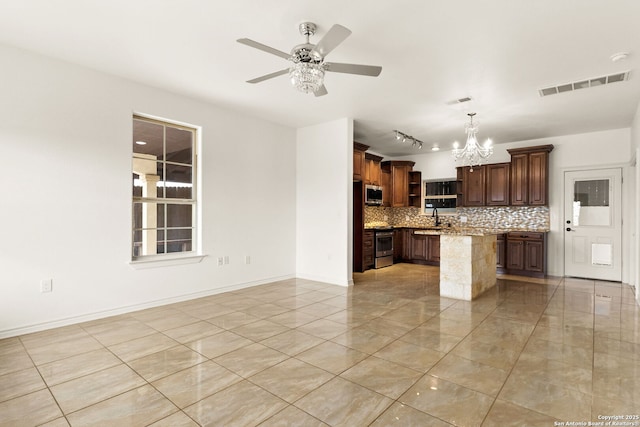 kitchen featuring stainless steel appliances, a sink, visible vents, backsplash, and a center island