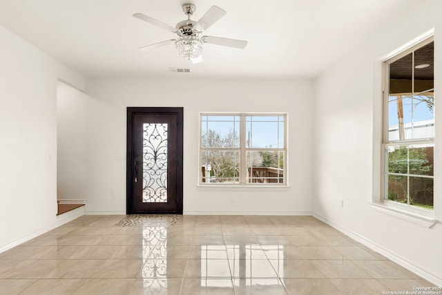 foyer entrance featuring baseboards, visible vents, ceiling fan, and a wealth of natural light