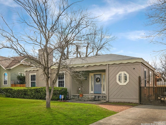 view of front of property featuring a gate, fence, and a front lawn