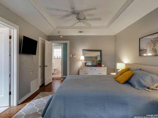 bedroom featuring visible vents, crown molding, and wood finished floors