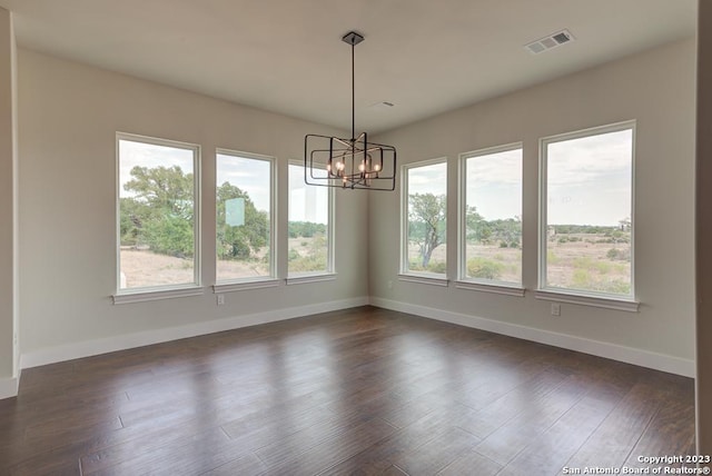 interior space with dark wood-style flooring, an inviting chandelier, visible vents, and baseboards