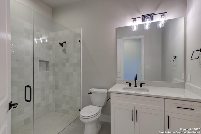 full bathroom featuring a stall shower, vanity, toilet, and baseboards